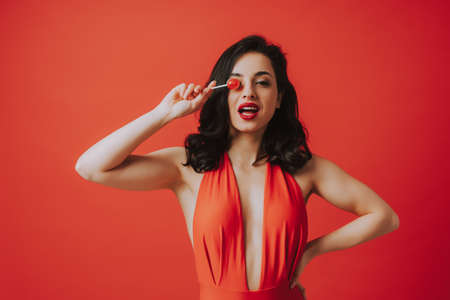 Image of a beautiful woman eating a fruity lollypop