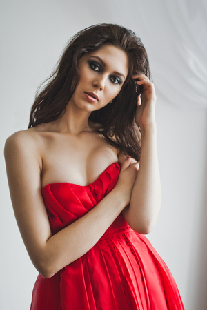 Girl in evening dress standing at the window.